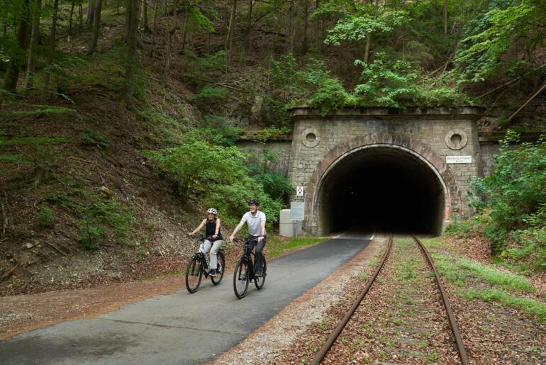 Radfahrer kommen aus einem Tunnel auf dem Kanonenbahnradweg