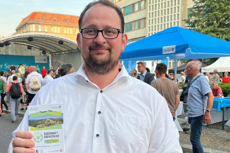 Dr. Thadäus König verteilt Flyer für den Deutschen Wandertag 2024 beim Thüringer Sommerfest 2023 in Berlin
